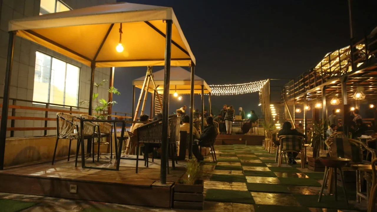 Rooftop seating at night with string lights